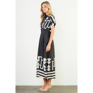 Woman wearing a black and white patterned dress on a plain background