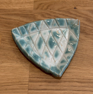 Decorative ceramic trinket dish with geometric pattern on a wooden surface
