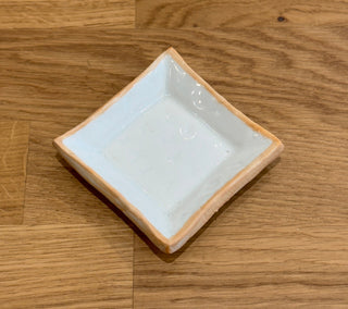 Small white ceramic dish on a wooden surface