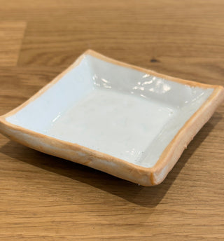 White ceramic square dish on a wooden surface