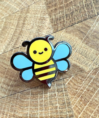 Cartoon bee pin on a wooden surface