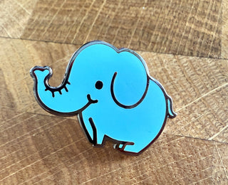 Blue elephant pin on a wooden surface