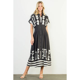 Woman wearing a black dress with white geometric patterns on a white background