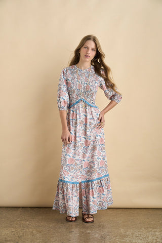 Woman wearing a floral dress against a beige background