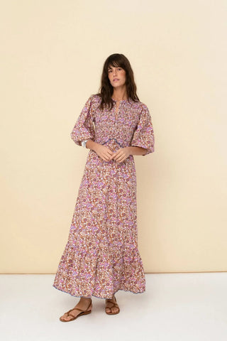 Woman wearing a floral dress against a beige background